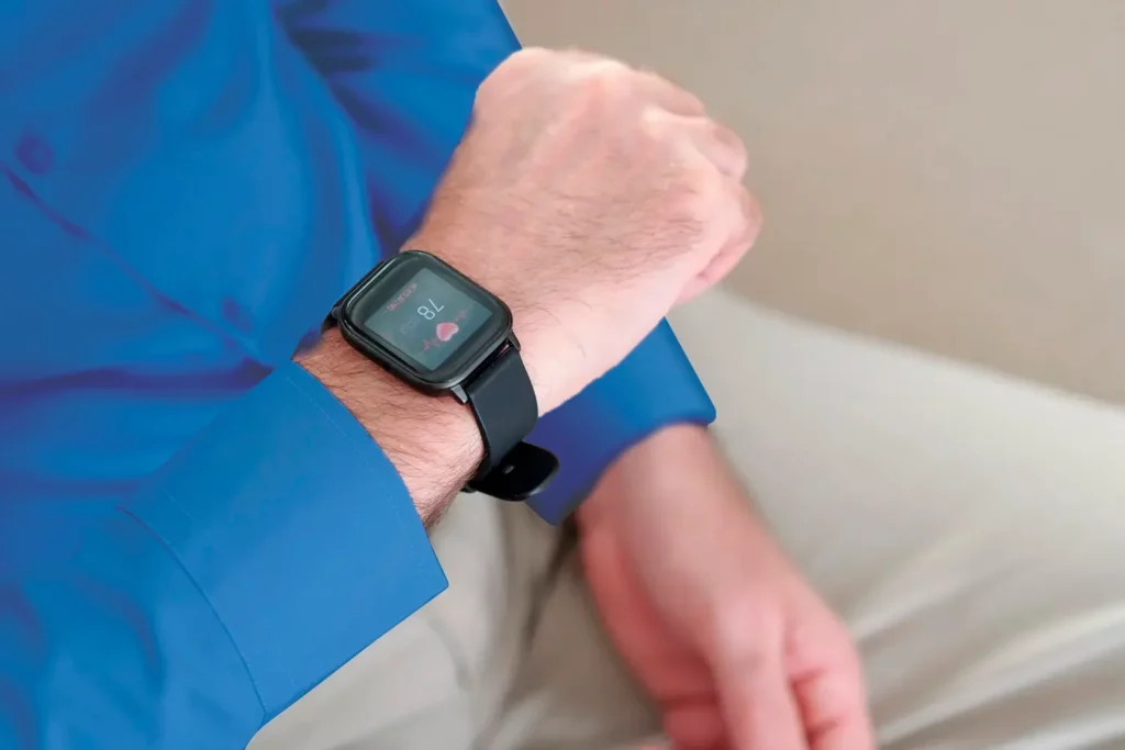 Hombre presentando taquicardia y revisando su ritmo cardíaco en un reloj.