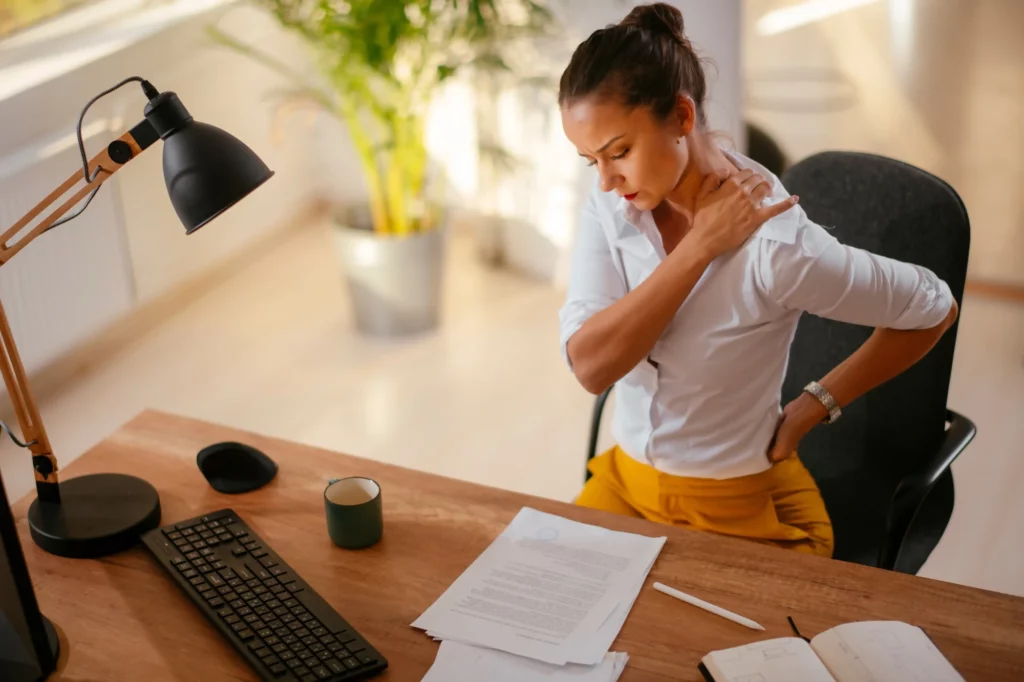 Mujer con dolor de espalda por estar sentada mucho tiempo