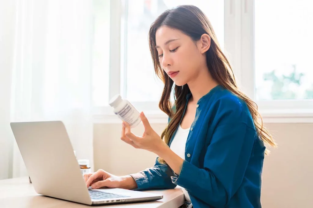 Mujer trabajando mientras ve su medicamento