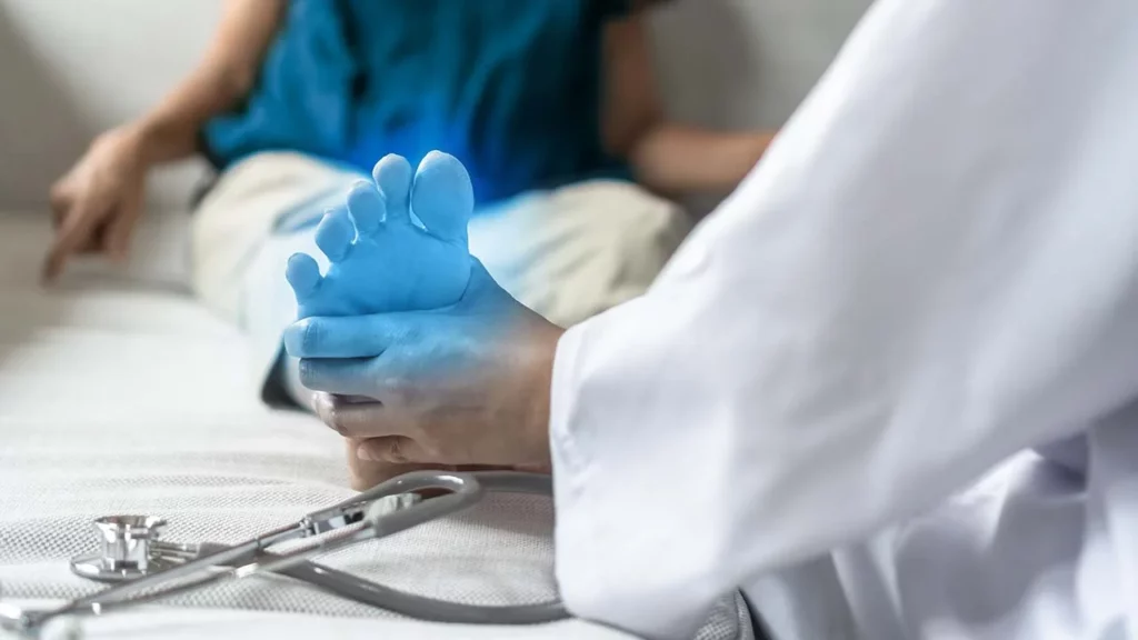 Imagen de un doctor tomando por el pie a un paciente para ejemplificar qué es neuropatía.