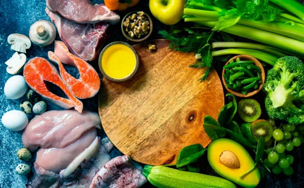  Alimentos diversos que componen una dieta keto como el salmón, pollo, aguacate y brócoli.