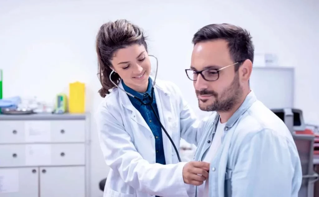 Doctora revisando a un paciente para identificar si hay enfermedades del sistema respiratorio que lo estén afectando.
