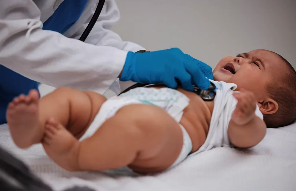 Médico escuchando si hay un soplo en el corazón de su paciente pediátrico.