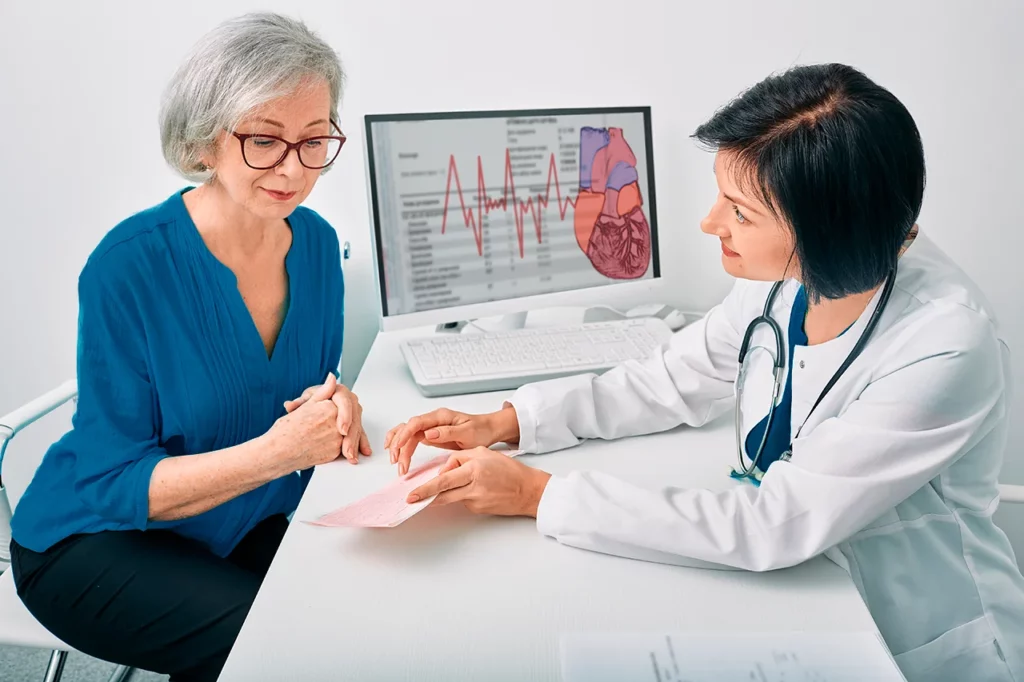 Una doctora presentando los resultados de un estudio a su paciente, indicando que es una arritmia lo que tiene